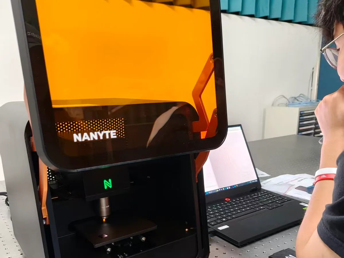 A NANYTE BEAM system on an optical bench, its objective focused over the sample stage while BeamXplorer runs on the laptop alongside